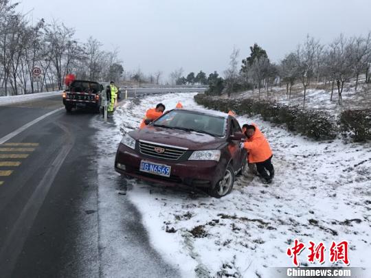  1月26日傍晚，一辆小轿车因为驾驶失误滑入彭泽互通绿化带内，被困1个多小时无法驶离。赣粤高速九江管理中心12名队员合力将小轿车推上高速。　江建龙 摄