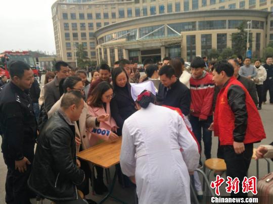 2月20日,在江西省赣州市宁都县人民医院门口,爱心人士排队为受伤人员义务献血。 李斌 摄