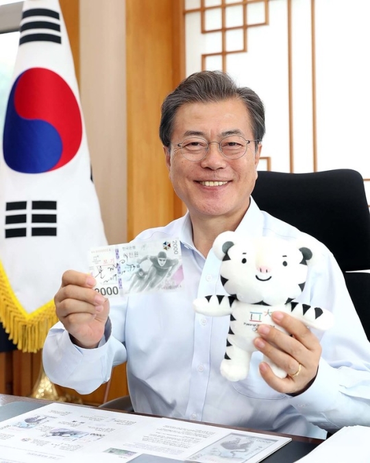 文在寅手持平昌冬奥会吉祥物做宣传