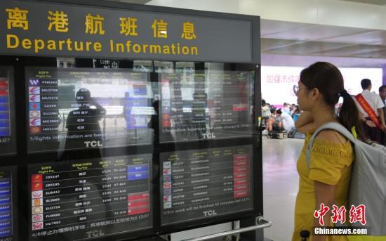 乘客在查看离港航班信息(资料图)。中新社记者 骆云飞 摄
