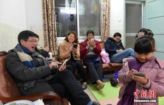 资料图:家人抢手机红包。 中新社记者 吕明 摄
