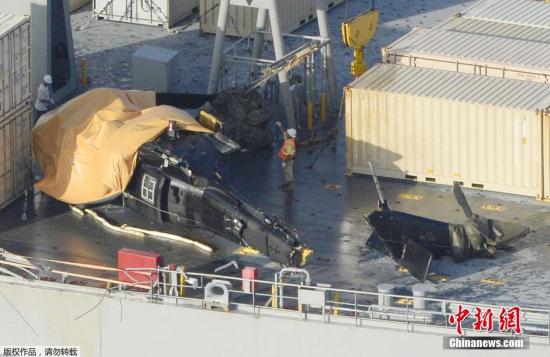 资料图：当地时间2015年8月12日，日本冲绳，美国海军舰甲板上的坠海直升机残骸。