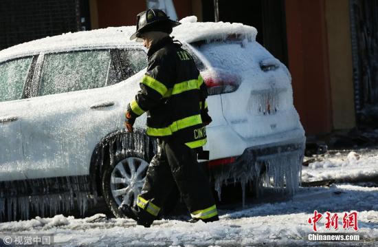 当地时间2018年1月2日，美国纽约，消防员对抗布朗克斯区的大火。火灾发生在寒冷的凌晨，据报道多人受伤，超过200名消防队员投入灭火。图为现场一辆汽车被冰封。