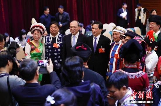 3月6日,十三届全国人大一次会议云南省代表团在北京举行全体会议,审议政府工作报告。图为全国人大代表、云南省委书记陈豪(左四)与全国人大代表、云南省省长阮成发(左三)在会后同参加会议的代表合影。 中新社记者 杜洋 摄
