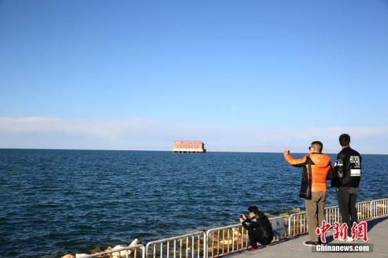资料图：青海湖二郎剑游客拍照留念。中新社记者 罗云鹏 摄