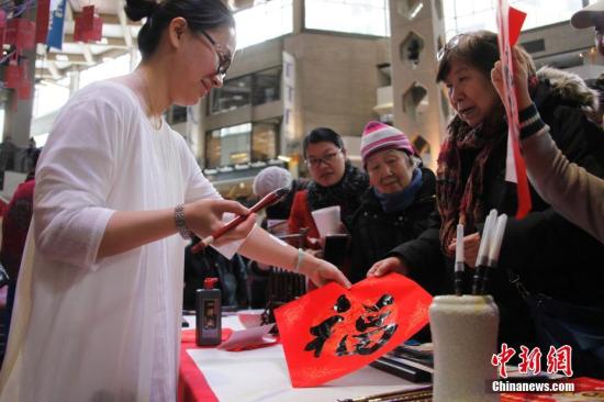 当地时间2月11日,加拿大第二大城市蒙特利尔举行欢乐春节庙会。图为女书法家在现场为华社民众题写挥春。这是蒙城连续第二年在农历新年前夕由华人社区联合举办欢乐春节庙会。参与筹办庙会的侨团由第一届的70多个增至本届的近百个。<a target='_blank' href='http://www.chinanews.com/'>中新社</a>记者 余瑞冬 摄