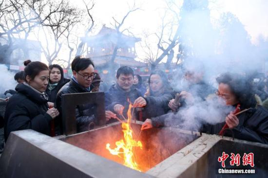 2月16日，民众在烧香祈福。当日，正值农历狗年正月初一，在北京雍和宫，大批市民赶在新年烧头柱香祈福。中新社记者 韩海丹 摄