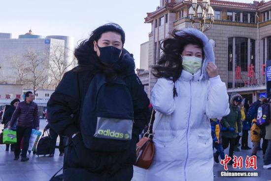 资料图:北京冬季天气持续干冷,民众在寒风中出行。 中新社记者 贾天勇 摄