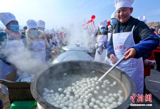 资料图：甘肃张掖市临泽县河西民俗博物馆工作人员在给当地群众和游客煮元宵。王将 摄