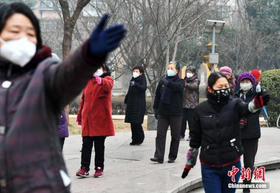 资料图:河北石家庄遭遇严重雾霾天气。图为市民戴口罩健身。中新社记者 翟羽佳 摄