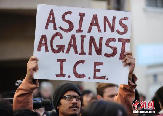 资料图：美国移民手举标语牌抗议。中新社发 陈钢 摄