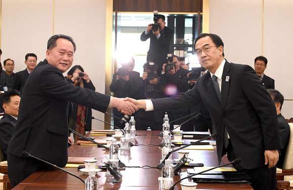 9日，韩朝高级别代表团团长在会谈前握手