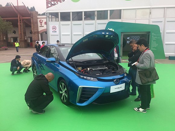 “氢能周”上，参观者围观丰田Mirai氢燃料电池汽车，并仔细查看位于车尾部的储氢瓶。 韩沁珂/摄