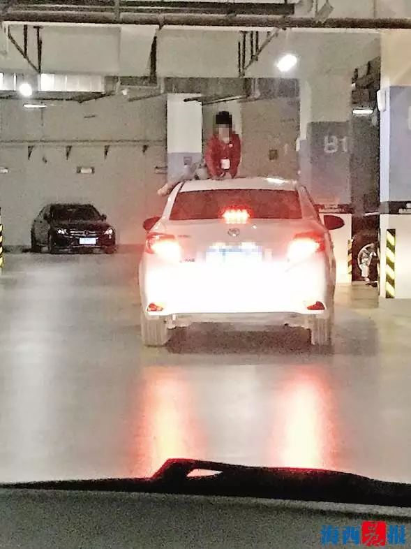 ▲地下车库内,女孩坐在车顶上