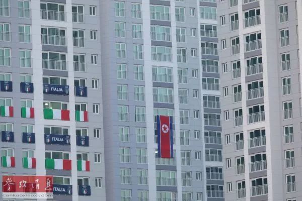 ▲江陵媒体村距离运动员村很近，记者在路过运动员村时看到悬挂在公寓楼外的一幅巨大的朝鲜国旗。（张越 摄）