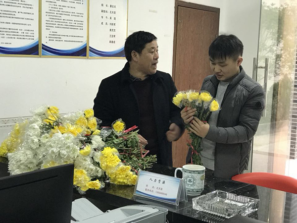 2月15日上午，黄材镇青羊社区书记姜征兵向前来的居民发放鲜花。 澎湃新闻记者 谭君 图