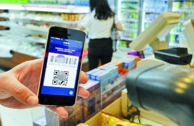 　▲图为超市扫描消费者手机上的二维码进行支付