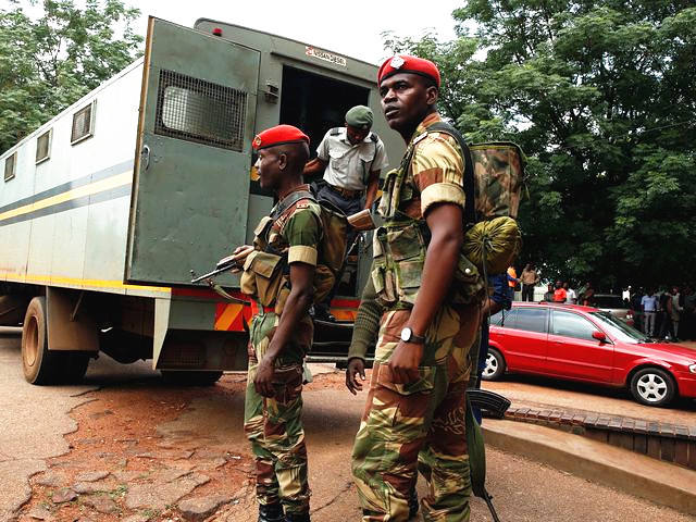 哈拉里，津巴布韦军方人员站在运送前财政部长的车辆旁警戒。（新华/路透）