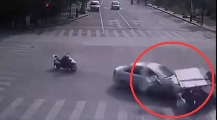 两位闯红灯的电动车闯过红灯，被横过而来的小车来了个一箭双雕。