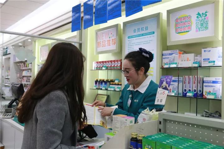 健之佳店员正在向顾客介绍本次活动的宣传折页