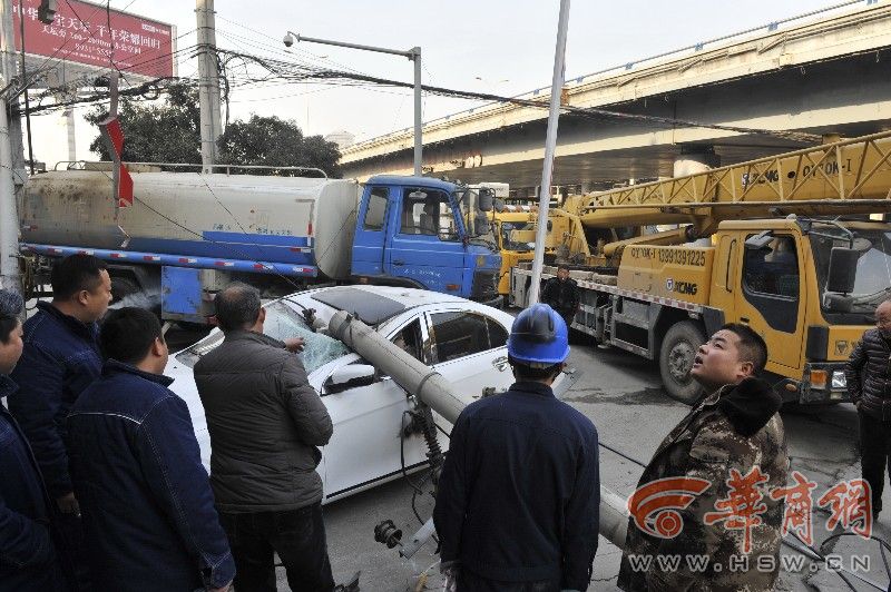 西安一送水车倒车撞断电线杆 一轿车被砸半个