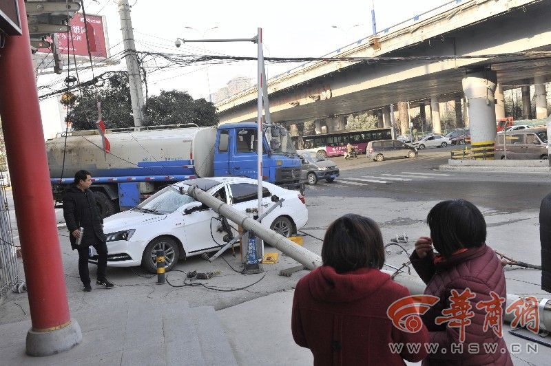 西安一送水车倒车撞断电线杆 一轿车被砸半个