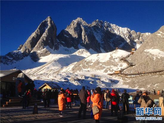 游客和摄影爱好者在玉龙雪山上拍摄新年第一缕阳光。王晓荣 摄