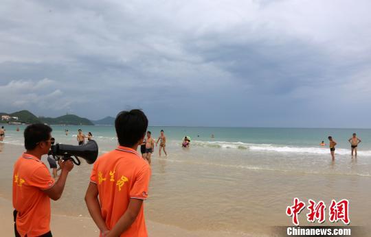 9月14日，三亚大东海景区海滩关闭，景区救生员提醒游客尽快离开海滩。　尹海明 摄