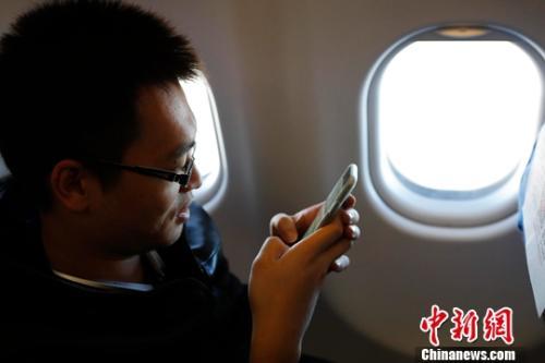 资料图:在东航MU5137航班上,旅客全程在飞行模式下可以使用手机。殷立勤 摄
