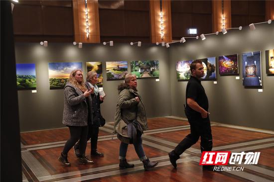 在“锦绣潇湘”图片展展区,德国市民被图片上美丽的湖南风光所吸引。