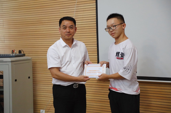 ▲湖南红石林旅游开发有限公司总经理李春给学生发放助学金
