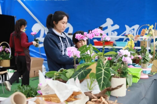 市民开心用券,花农打包忙,现场一片热闹。