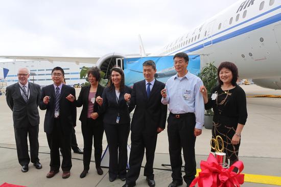 交付仪式上，国航与波音双方的工作人员展示象征着这架787-9飞机所有权的飞机钥匙