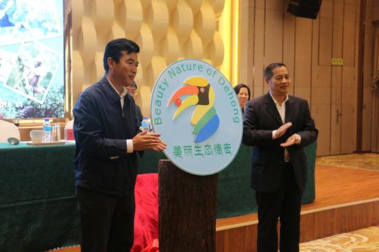 德宏州委书记王俊强与中国野生动物保护协会秘书长李青文为犀鸟logo