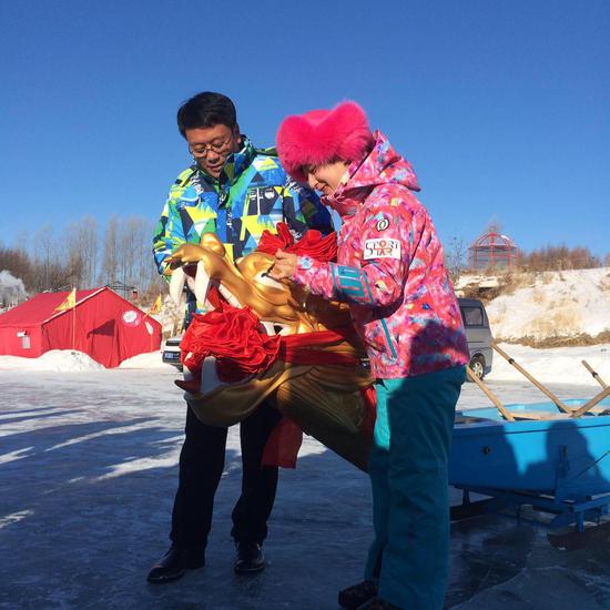 嘉荫县副县长张仙峰与世界滑雪冠军郭丹丹共同为冰上龙舟画龙点睛