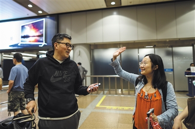 制伏飞机上袭击者的中国男子侯爽与同机乘客挥手告别。