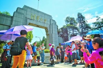 昨日上午11时，清华大学西门处，游客在校门前拍照。由于周一清华大学不对外开放，前往游览的游客只得在门口留影纪念。实习记者武亦彬摄