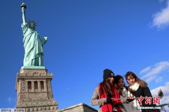资料图：美国纽约，游客在自由女神像前自拍