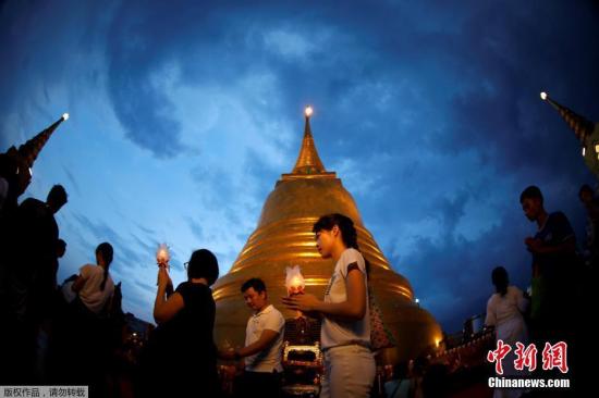 资料图：当地时间2017年5月10日，泰国各地民众庆祝卫塞节，民众手举蜡烛祈祷。