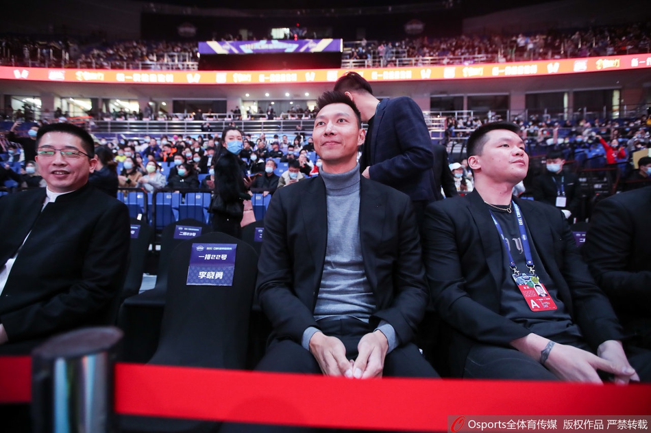 易建联身着一袭笔挺黑西装,与身旁的朱芳雨、胡卫东低声交谈,久违露面的大哥气场沉稳,眼神温柔地投向球场中央。