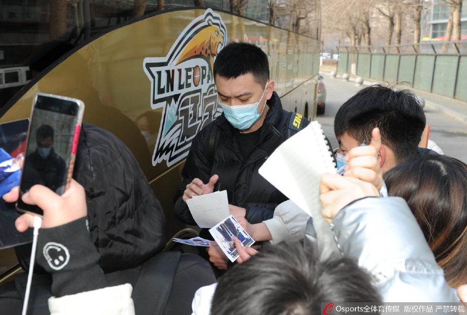 大巴车内，一位球员侧身望向窗外，玻璃上倒映出外面送行人群模糊的影子。车内车外，虽然隔着一层冰冷的玻璃，心却在这一刻贴得最近。