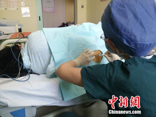 北京医院的一名麻醉医生正在为孕妇打“无痛”。 中新网记者 张尼 摄