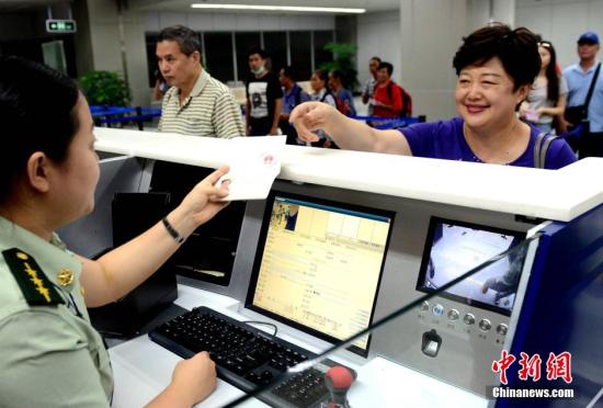 资料图：台胞在福州机场边检站办理办理入境手续时免签注，经过人像对照和核查证件有效无异常后顺利通关。 中新社发 刘可耕 摄