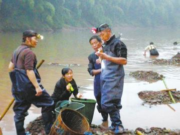 杨建在帮当地村民鉴定挖起来的石头