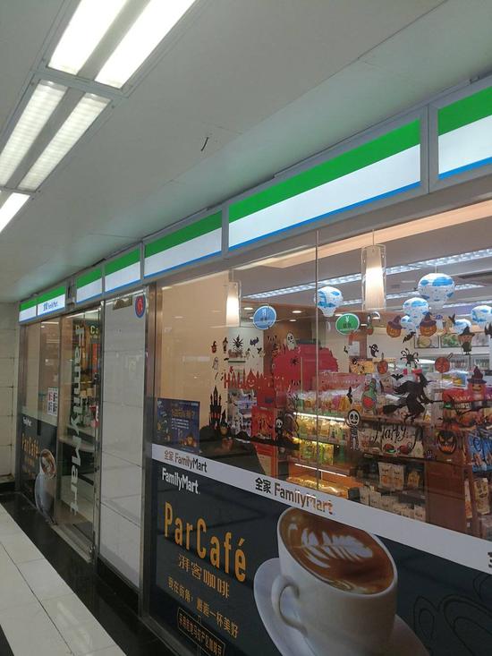 人民广场地地铁站的全家便利店,一位顾客正在店内休息。