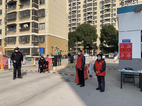 泰伯一社区党员志愿者吕勤南站好门岗