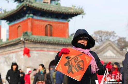 资料图:农历腊月廿三小年儿来临,北京东岳庙举办迎新春送春联活动,参与者甚众。中新社记者 富田 摄_副本