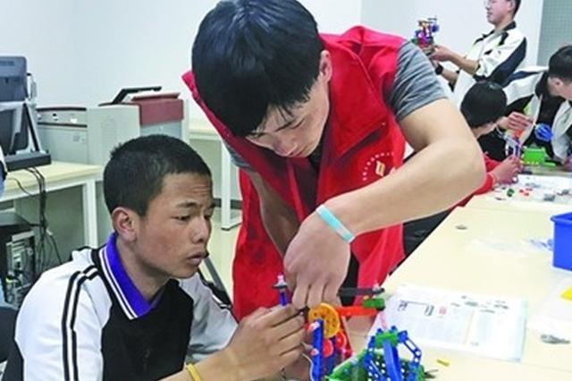 图为青海玉树中学生在锡体验乐高机器人。 (春贤 摄)