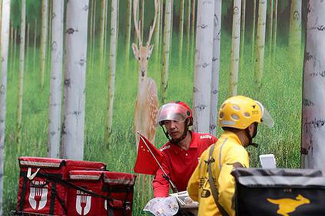 资料图:5月23日,北京西单街头的外卖骑手准备送餐。 中新社记者 张宇 摄