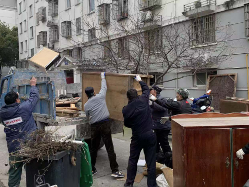 图为清理非机动车车库内的杂物、垃圾。